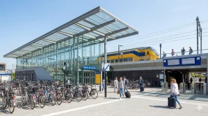 NS station Alphen aan den Rijn met perrons en reizigers, centraal gelegen aan Stationsplein in de stad